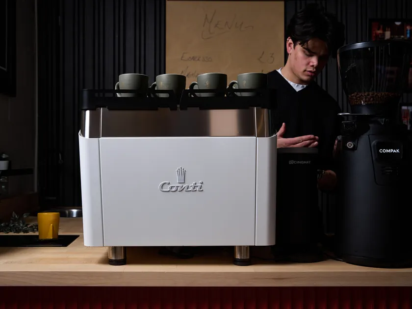 Barista achter de witte Conti NG-E espressomachine
